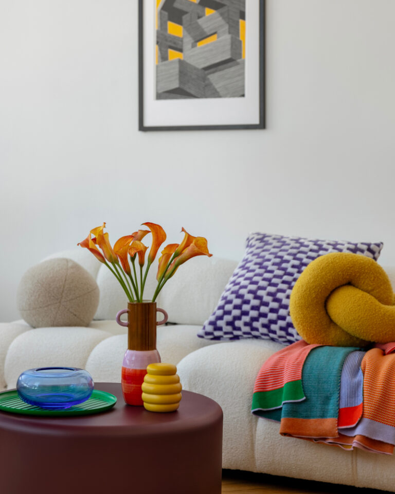 white couch with brightly colored pillows and accessories